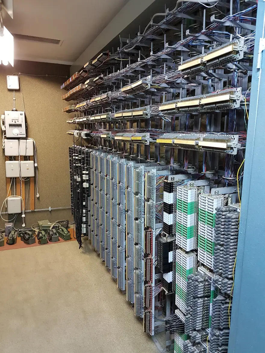 A wall of Cold War telephone switchboard racks packed with coloured wiring inside the ARK bunker