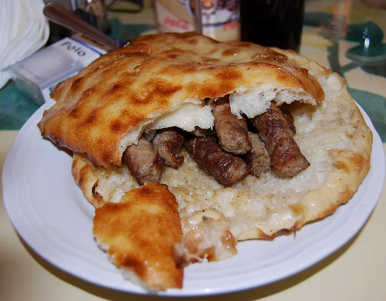 A plate of cevapi, grilled minced-meat fingers in fresh somun flatbread, in Travnik