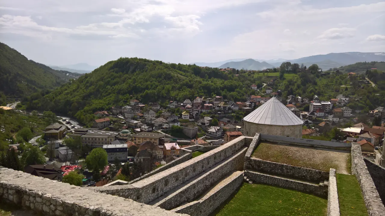 The ramparts and round tower of Travnik fortress with the old town in the valley below