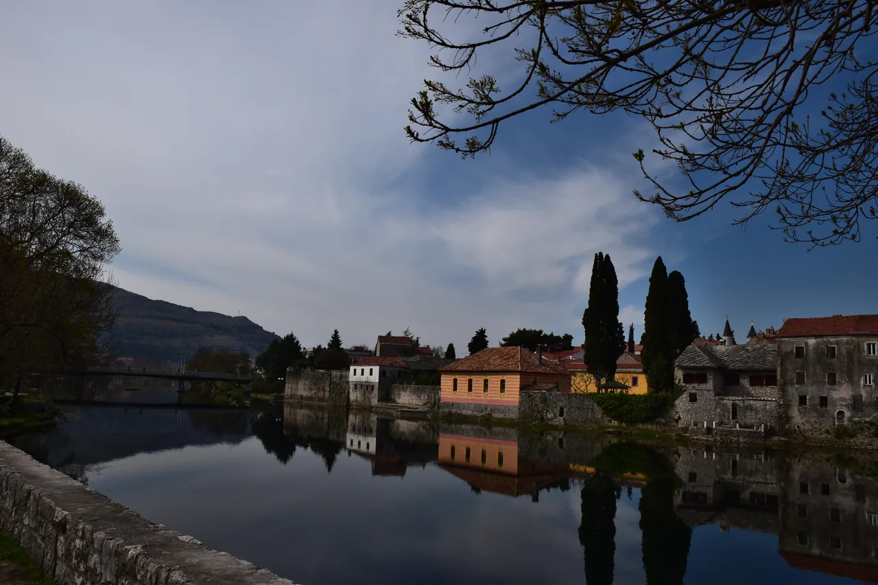 The town of Trebinje spread along the green Trebišnjica river below the bare ridge of Mount Leotar