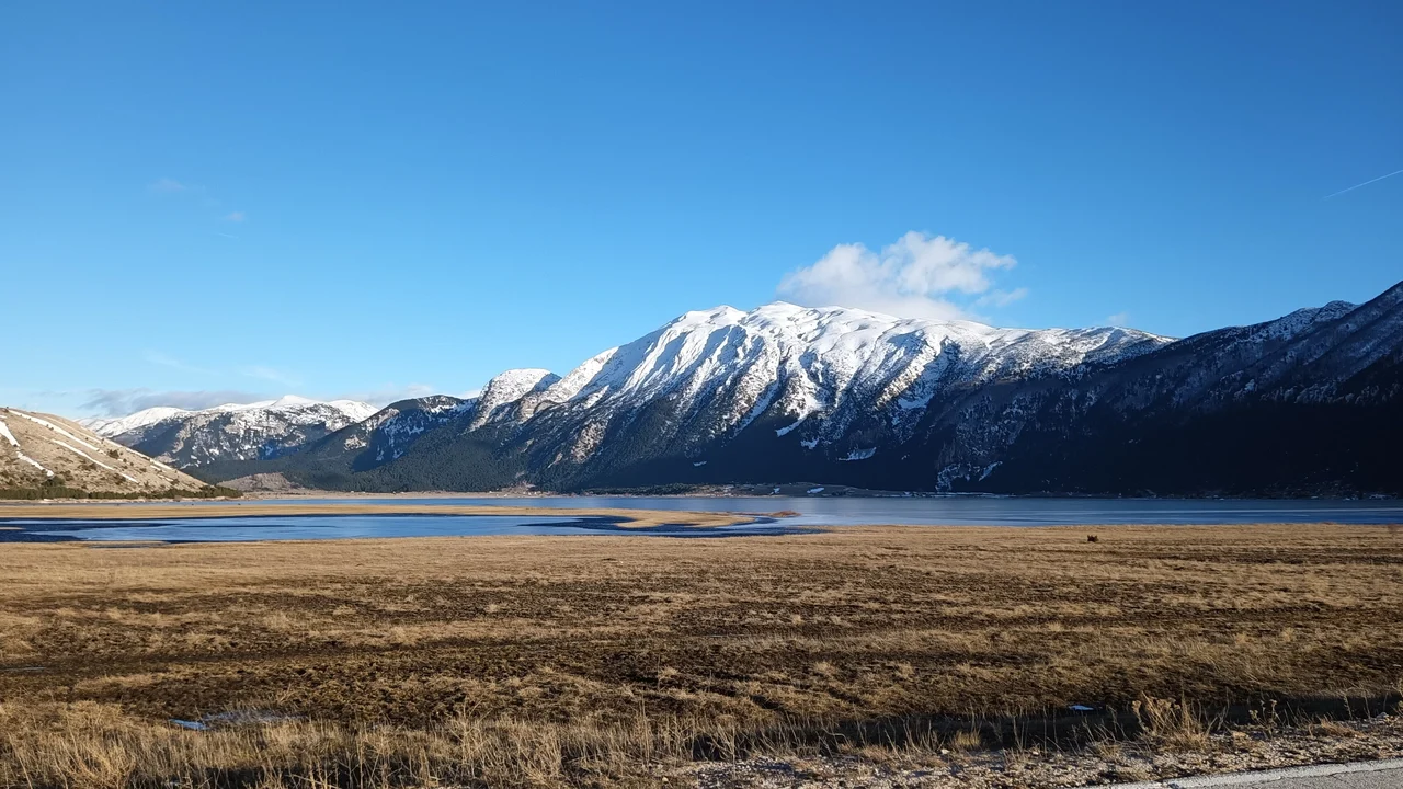 The wide Blidinje plateau and lake basin below the snow-streaked ridge of Vran mountain