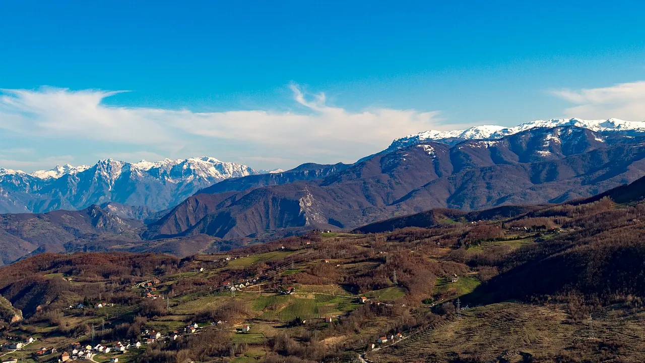 Wide limestone ridges of Prenj and Čvrsnica rising above forested valleys in Herzegovina under a clear sky