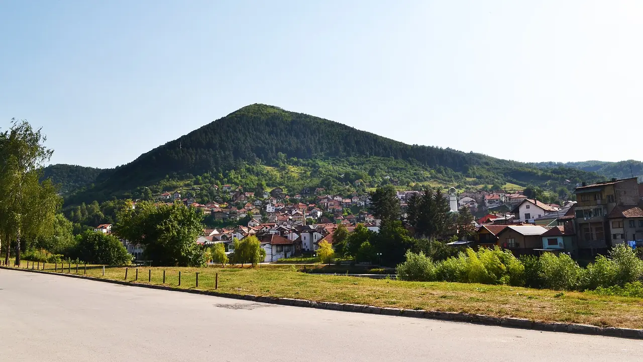 The steep, strikingly triangular Visočica hill (the Pyramid of the Sun) rising over the rooftops of Visoko under moody cloud