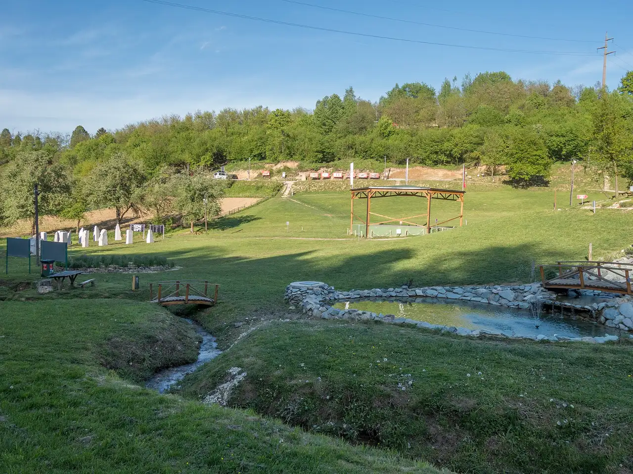 The manicured lawns, gazebo and small pond of the Ravne 2 archaeological park near Visoko