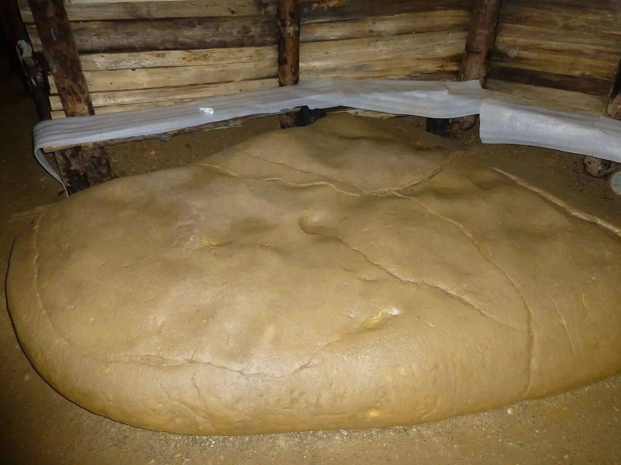 A large smooth sandstone boulder inside the timber-shored Ravne tunnel, presented on tours as an ancient megalith