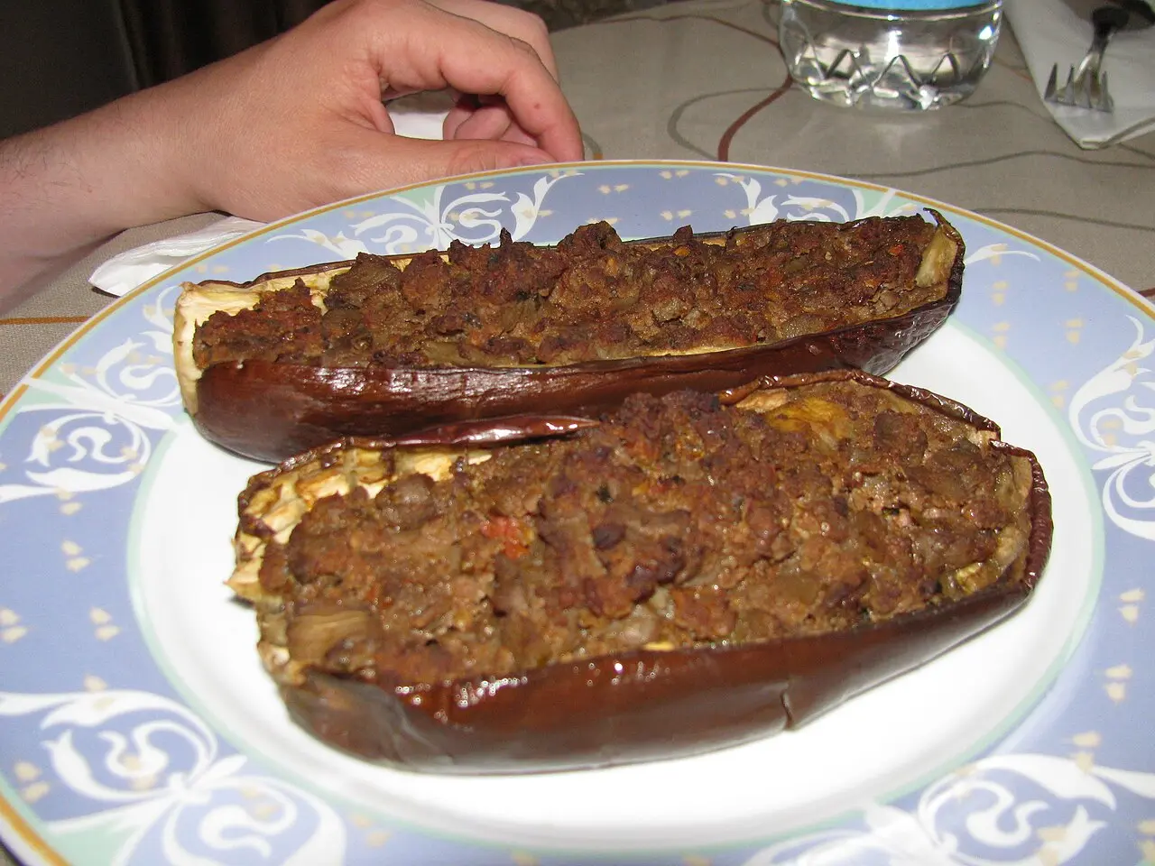 Two halves of stuffed aubergine filled with minced meat on a patterned plate in a Sarajevo restaurant