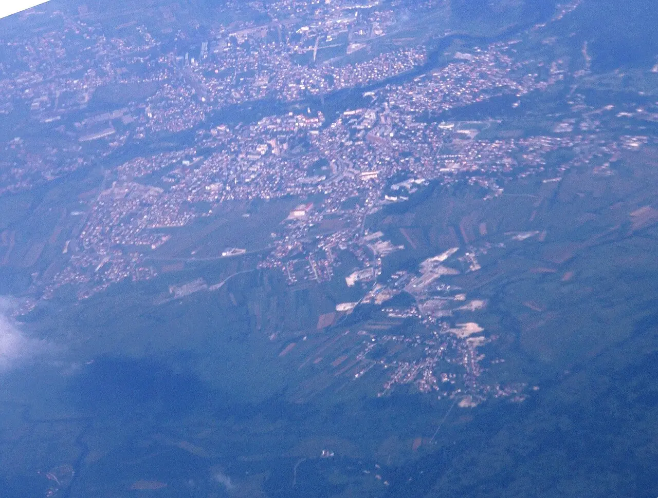 The town of Bihać seen from the west, spread along the Una river with a church tower and minarets
