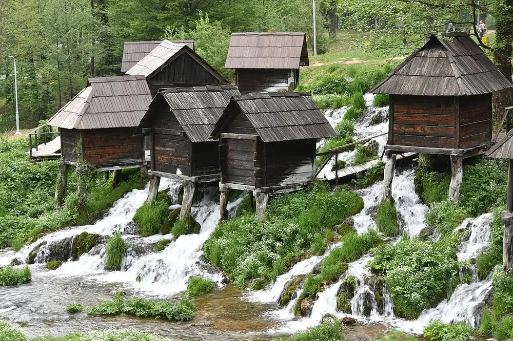 The wooden Pliva watermills of Jajce standing over rushing streams and bright green grass