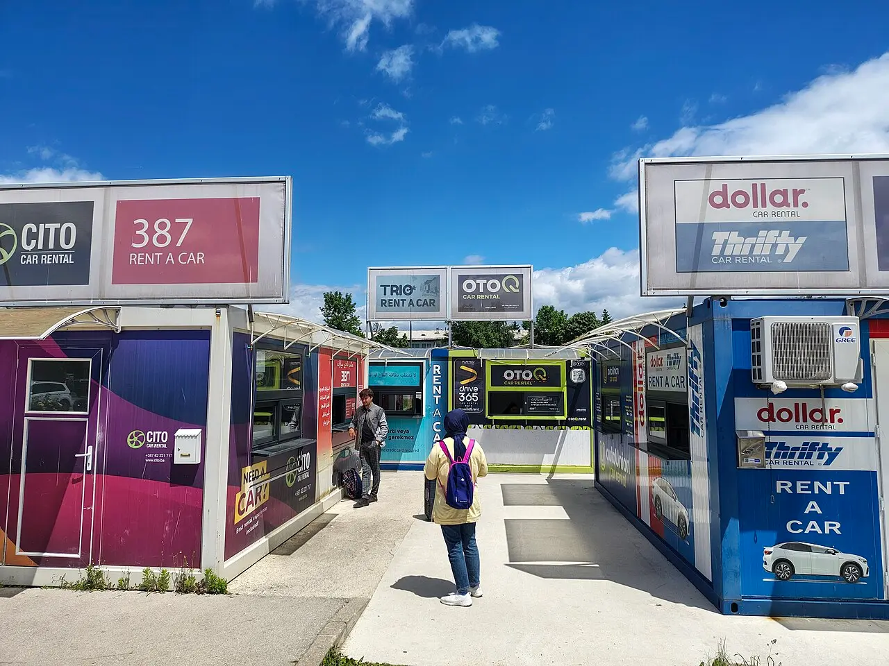A row of car rental company kiosks inside the arrivals area of Sarajevo International Airport